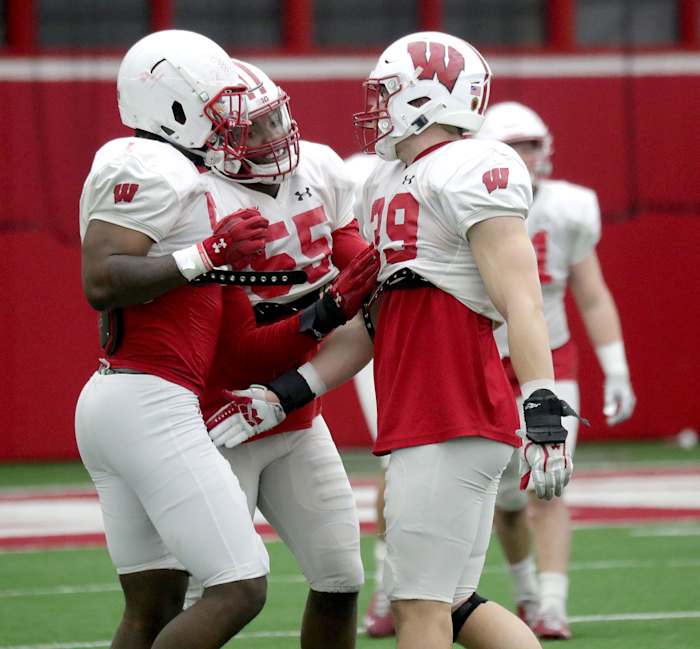 Wisconsin inside linebackers Jordan Turner (54), Maema Njongmeta (55), and Tate Grass (39) talk during spring practice. (Credit: Mike De Sisti / Milwaukee Journal Sentinel / USA TODAY NETWORK)